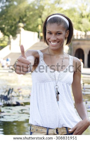 Woman gives thumbs up. Focus is on her face.