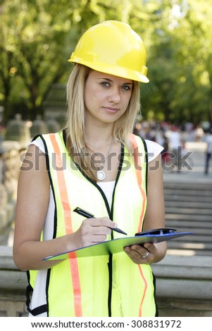 A female utility worker with clipboard.