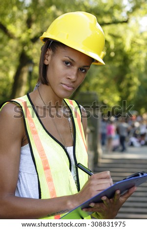 A female utility worker with a clipboard.