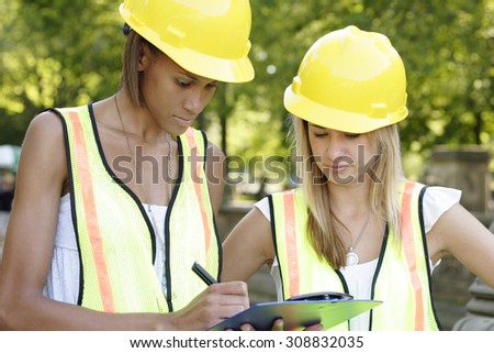 Two utility workers with clipboard.