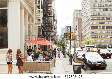 New York, New York, USA - June 20, 2011: Diners at outdoor seating at a restaurant on Church Street in the Tribeca section of Lower Manhattan. People can be seen on the street.