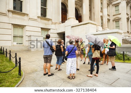 New York, New York, USA - August 14, 2012: A tour guide speaking to a tour group at the Tweed Courthouse in Lower Manhattan. It was built in the latter 1800\'s.