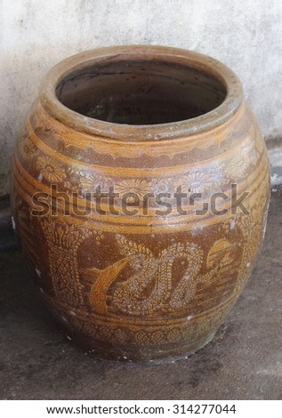 Old glazed water jar with dragon pattern