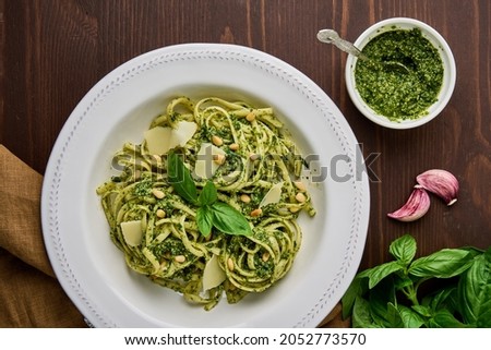 Classic italian pasta pesto with pine nuts, pound garlic, basil leaves, hard parmesan cheese and extra-virgin olive oil. Mediterranean pesto sauce and tagliatelle. Healthy homemade vegetarian ストックフォト © 