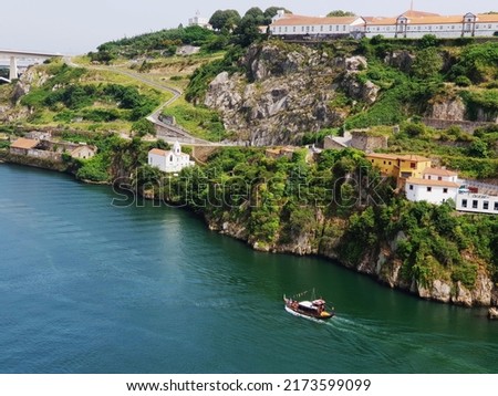 A boat sailing on the Douro River under the steep river shore with Porto winemakers buildings and the beautiful Monastery Serra do Pilar in this aerial view during a sunny day in Porto, Portugal Foto stock © 