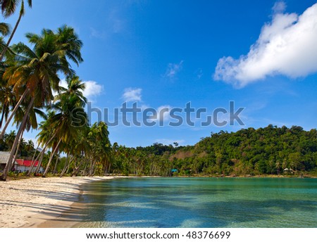 Family hotel on the tropical beach with white sand near sea water and blue sky