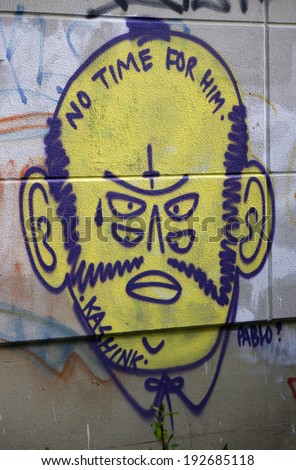 CIRCA MAY 2014 - BERLIN: street art: a graffity of a yello faced man with four eyes in the Schoeneberg district of Berlin.