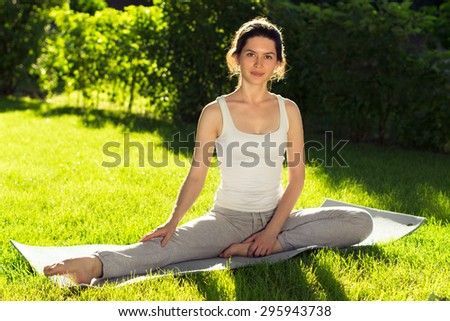 Young beautiful woman doing yoga in the park in the morning