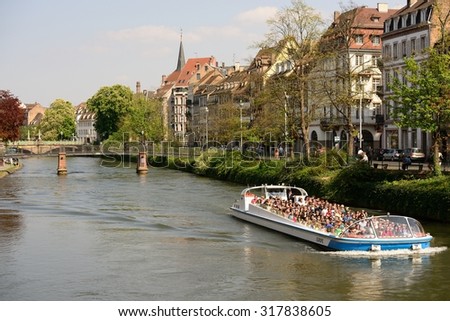 STRASBOURG, FRANCE - CIRCA APRIL 2014: tourists enjoy ride on sight-seeing boat thru one of the local canals circa April 2014.