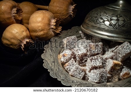 Macro view of Turkish delight in hollowware with dried poppy heads. Traditional Turkish sweet double roasted with pistachio nuts and coconut in a metal oriental bowl. Foto d'archivio © 