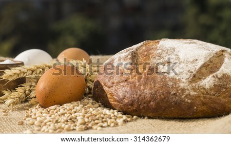 Tablet PC. top view. bunch an ear of wheat. and eggs and a loaf of bread grain and salt