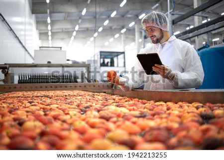 Technologist in food processing factory controlling process of apple fruit selection and production. Foto stock © 