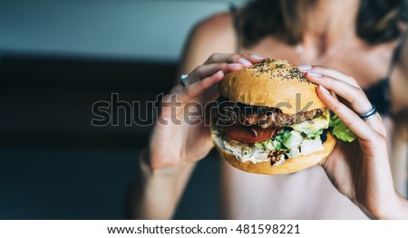 Similar – Image, Stock Photo Hands holding a cheeseburger with lettuce and tomato