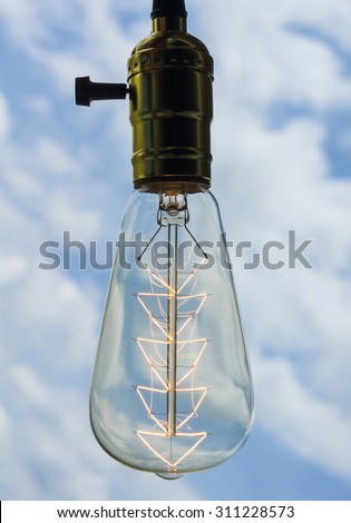Abstract Vintage Energized Light Bulb Look Like Christmas Tree Over Light Blue Sky With Clouds