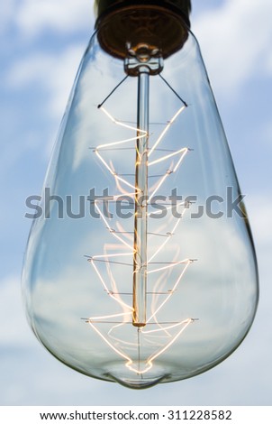 Abstract Vintage Energized Light Bulb Look Like Christmas Tree Over Light Blue Sky With Clouds