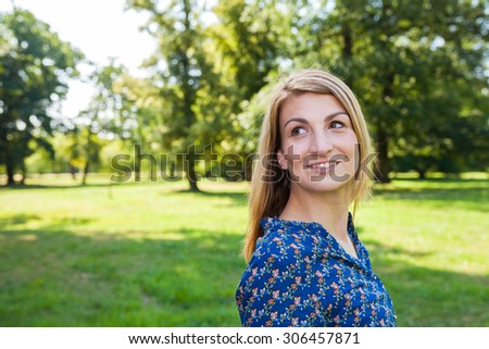 young woman in the park looking left to space