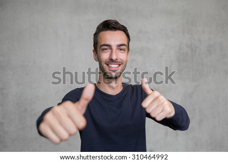thumps up portrait of a young man smiling