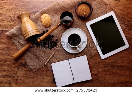 The working environment is on the table plate and notepad, close fragrant fresh mug of coffee, there is not much in the ?ezve beverage for another mug of coffee for you