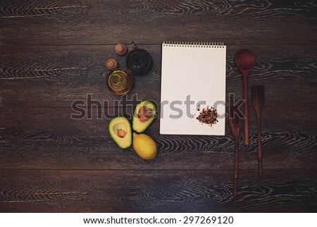 Cook wrote in his notebook for recipes cookbook near notebook is sliced avocado and lemon