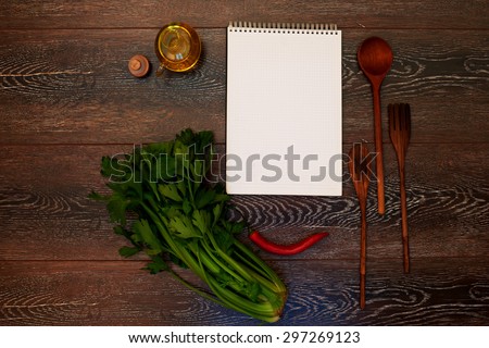 A place for advertising, ads or menu notebook lying on a wooden table next to the kitchen, wooden cutlery, olive oil