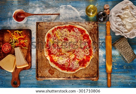 On the table lies a vintage wooden thin-crust pizza, with sausage, onion and tomato cheese, light and nourishing