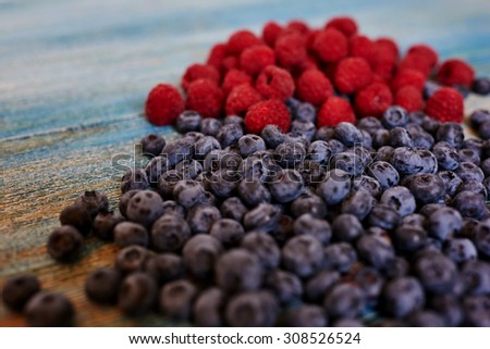 Assistant Cook laid on the table fresh berries to sort out and select the most ripe and sweet