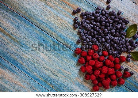 The large blue table gardener laid fresh berries to wash them and to sort