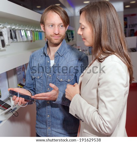 Shop assistant helping a customer choosing a phone