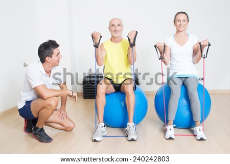 Physical therapist showing skipping rope exercise to a couple of seniors