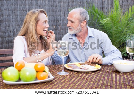 Elderly couple having food on terrace