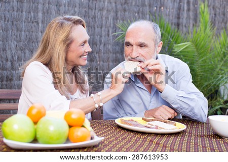 Elderly couple having food on terrace