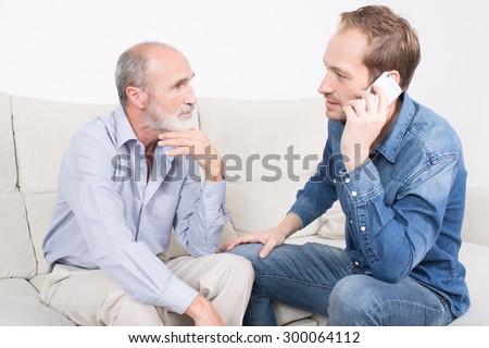 Elderly son calling his mother while father looking