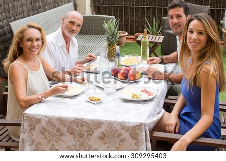 Family having food in garden and looking into the camera