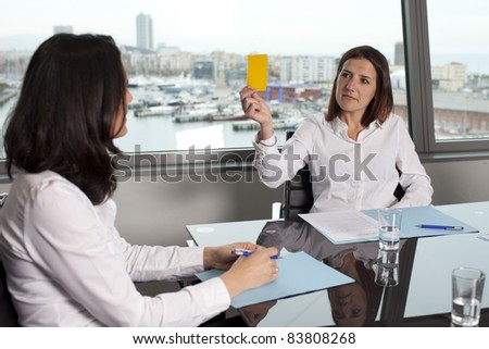 Woman showing the yellow card as warning in office