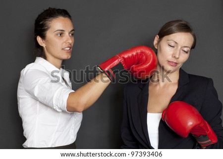 businesswoman hitting with red boxing gloves