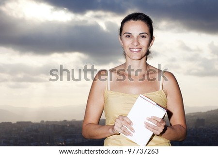 Latin woman reading a book outside
