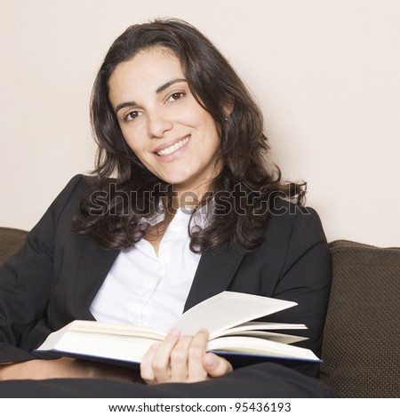 Attractive woman sitting on couch and reading a book