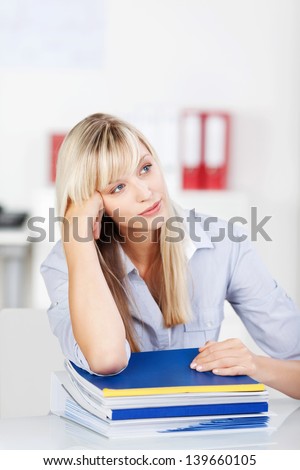 Portrait of woman thinking and lying her elbow on the books