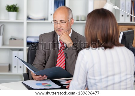 businessman in interview with woman looking at cv