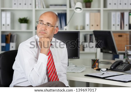 employee with hand on chin looking to side in thought