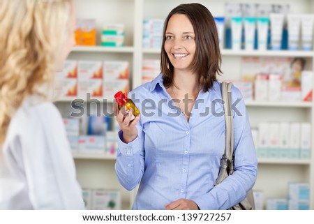 Happy smiling customer with a pharmacist in a pharmacy
