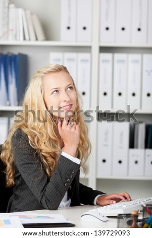 Thoughtful young beautiful blond businesswoman looking up
