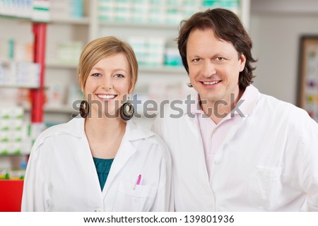 Portrait of happy male and female pharmacists in pharmacy