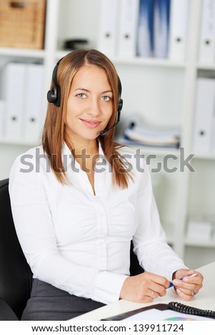 Portrait of happy female customer service executive sitting at office desk