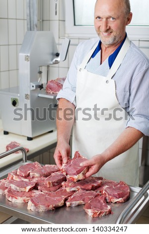 Butcher holding a lump of raw meat from many