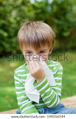 Little boy covering his nose because of allergy