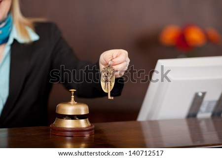 receptionist passing room keys over the counter