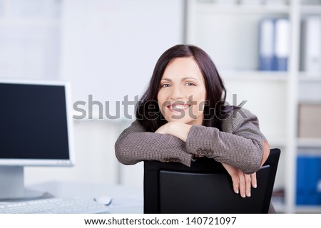 Happy businesswoman laying her chin in her arms