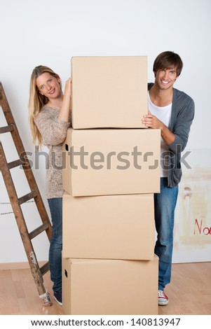couple standing beneath a batch of boxes