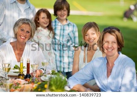 happy family having dinner in the garden in summer